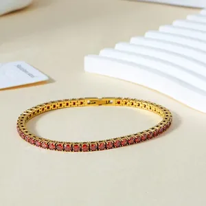 Detailed macro view of 3mm red zircon tennis bracelet with gold-plated stainless steel clasp
