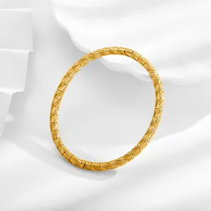 Detalle macro del brazalete de acero inoxidable dorado de 18K con textura trenzada