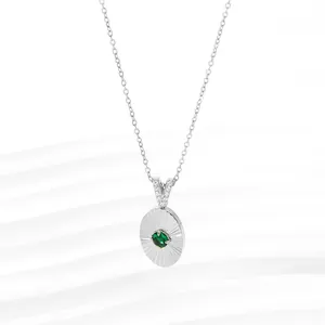 Macro view of a 18K silver-plated necklace featuring a green gemstone pendant