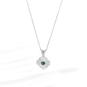 Close-up of silver titanium steel necklace with green gemstone flower pendant and diamonds