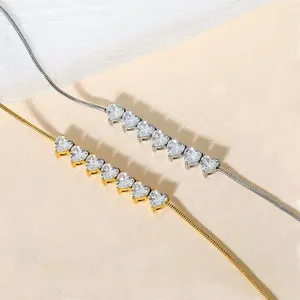 Detailansicht goldener und silberner Herz-Zirkonia-Tennisarmbänder im Schlangenkettendesign
