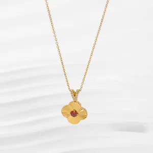 Detailed macro of golden flower pendant with radial texture and red gemstone center