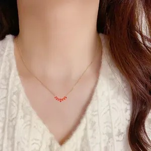 Elegante goldene Titanstahlkette mit orangefarbenem Zirkon-Fächeranhänger am Model