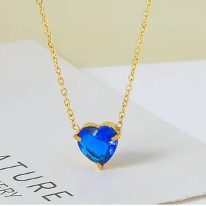 Detail van een hartvormige blauwe zirkoon hanger ketting met een fijne gouden ketting