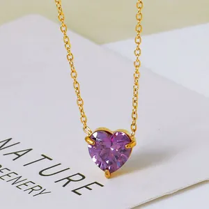 Macro-opname van een paarse hartvormige zirkoon hanger aan een fijne gouden titanium ketting