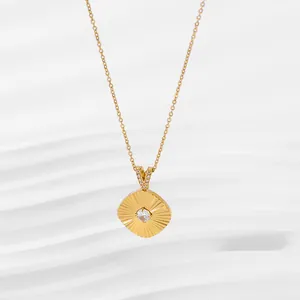 Close-up of golden necklace with square radiant pendant and central zircon stone