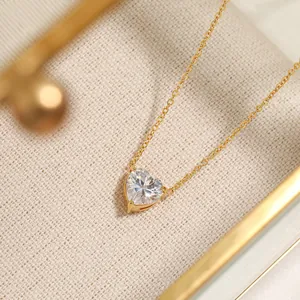 Detailopname van hartvormige zirkoon hanger met vergulde titaan stalen ketting