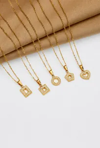 Detail of five gold titanium steel necklaces with sparkling cubic zirconia geometric charms