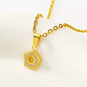 Macro view of gold geometric pentagon pendant with sparkling zircon inlay on a fine chain