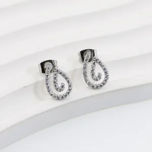 Macro detail of silver teardrop stud earrings with hollow design and pave white cubic zirconia