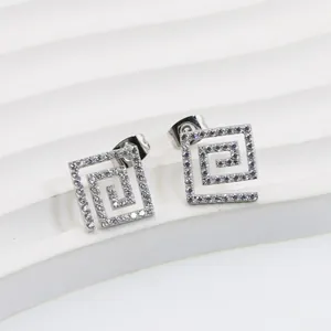 Macro shot of silver titanium steel square stud earrings with micro-set zircon stones