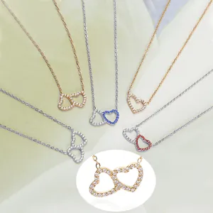 Close-up of titanium steel heart necklaces with colorful crystals in gold and silver