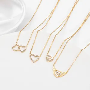 Macro shot of four gold heart pendants with shimmering pavé crystal details on silk