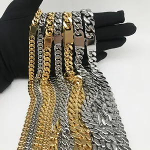Polished gold and silver Cuban link chains with square buckles held in black gloved hands
