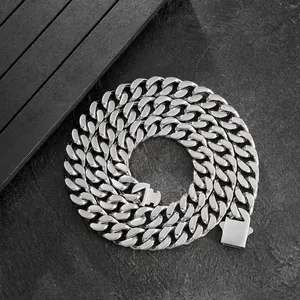 Polished silver cuban link chain with rectangular clasp on a dark stone background