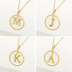 Detalle de cuatro colgantes de letras doradas M, J, K, A con micro-incrustaciones de circonitas