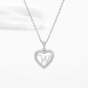 Macro shot of silver heart pendant with crystal border and cutout letter W design