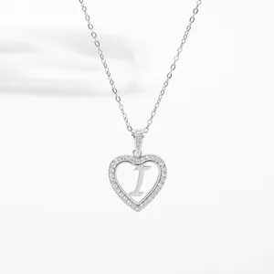 Detailed macro view of silver heart pendant with letter I and cubic zirconia settings