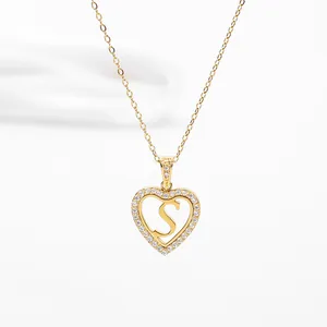Close-up of gold heart pendant necklace with a letter S and sparkling zircon stones