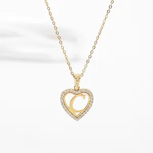 Macro shot of gold-plated heart pendant featuring letter C and sparkling zircon stones