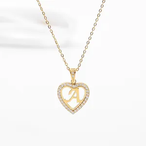 Detailed view of heart-shaped gold pendant with pavé crystals and letter A on fine chain