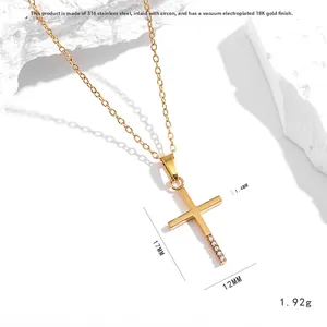 Collar de cruz en acero inoxidable dorado con circón sobre fondo de piedra