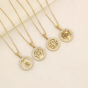 Detail van vier gouden titanium stalen kettingen met kristallen hangers en hamsa-hand detail