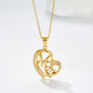Macro-opname gouden hartvormige hanger met Mom-gravure en witte zirkonia steentjes