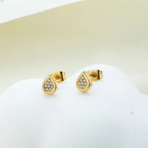 Detailed view of golden teardrop stud earrings with pavé set white zircon stones