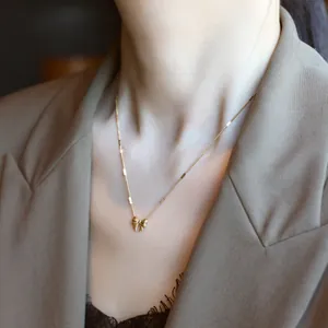 Elegante goldene Titan-Halskette mit Schleifenanhänger am Model für einen luxuriösen Look