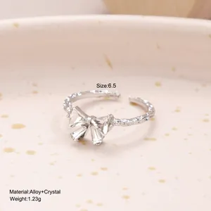 Détail d'une bague en alliage argenté avec nœud en cristal et anneau à texture martelée