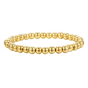 Détail macro du bracelet à perles dorées polies avec une finition métallique lisse