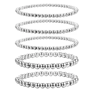 Ensemble de cinq bracelets extensibles en perles de métal argenté de tailles variées