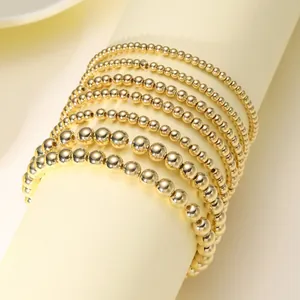 Acht-delige set gouden kralenarmbanden met gepolijste metalen afwerking voor gelaagde look