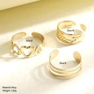 Three-piece gold alloy rings set featuring heart design and layered adjustable bands
