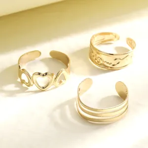 Detailed view of three-piece gold heart cutout and layered adjustable toe rings set
