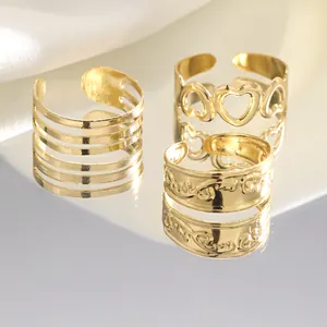 Detailed view of three gold open rings featuring hollow hearts and textured wave patterns