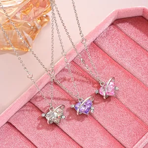 Detailed view of heart planet pendants with purple, pink and white zircon crystals