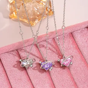 Detail of heart-shaped planet necklaces with purple and pink zircons on velvet