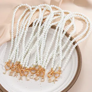 Detailed view of pearl necklaces with gold OT toggles and crystal letter pendants
