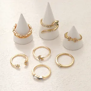 Elegant 6-piece golden ring set with snake and star patterns on white jewelry stands