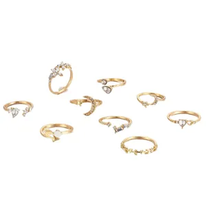 9-piece gold knuckle ring set featuring moon, heart, and crystal designs on white background