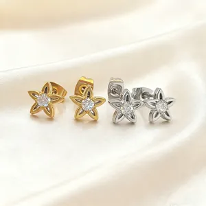 Detailed view of two pairs of five-petal flower earrings in gold and silver finish