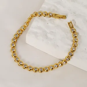 Detailed close-up of gold titanium steel tennis bracelet with circular bezel-set zircons