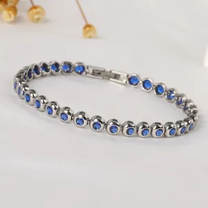 Detailed macro view of silver tennis bracelet with deep blue round-cut cubic zirconia stones