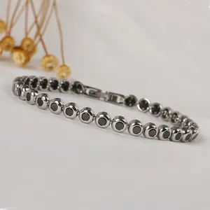 Macro shot of silver stainless steel chain bracelet with round black carbon fiber insets