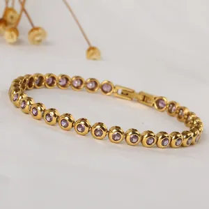 Detailed macro view of a gold-plated tennis bracelet featuring purple round-cut cubic zirconia