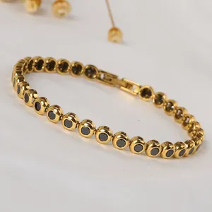 Close-up of gold titanium bracelet featuring black zircon stones and secure folding clasp