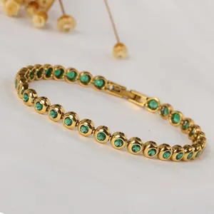 Detail of a gold titanium steel bracelet with sparkling green round zirconia stones