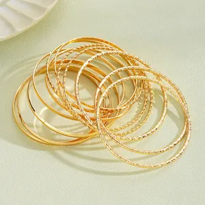 Dettaglio del set di bracciali bohémien dorati con motivi strutturati e finiture lucide